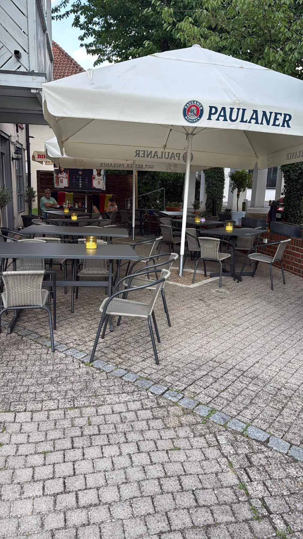Terrasse des Volapük Bistro mit Sitzplätzen und Sonnenschirmen